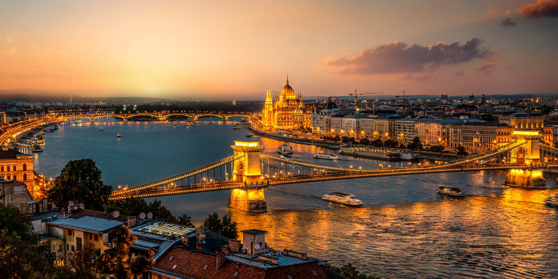 The Danube at dusk in Budapest, the Chain Bridge and Parliament lit up, linking Buda and Pest.