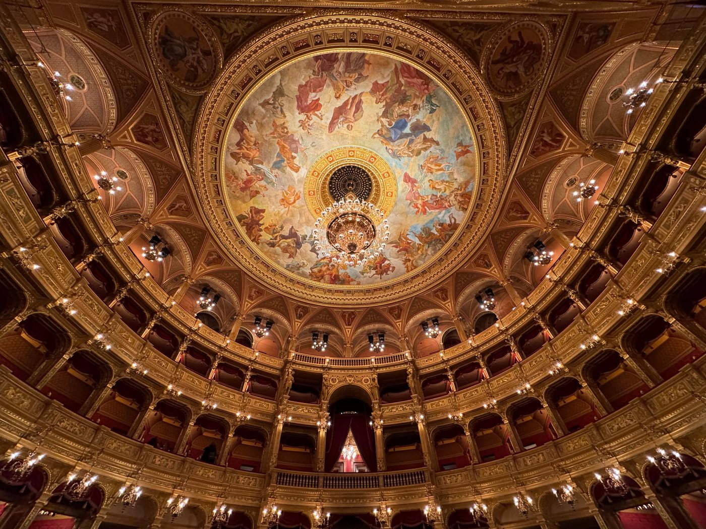 The frescoed ceiling and gilded balconies of the Hungarian State Opera, in Pest.