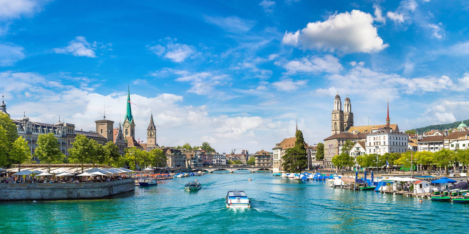 Panorama of Zurich's old town and the Limmat, with the Grossmünster and Fraumünster, on a summer's day.